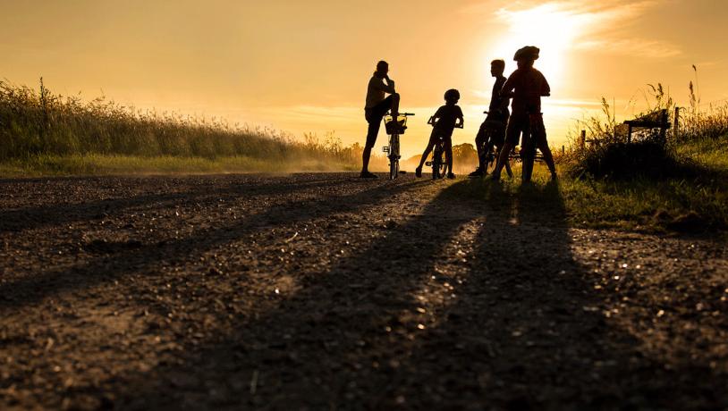 Familie på cykelferie i solnedgang