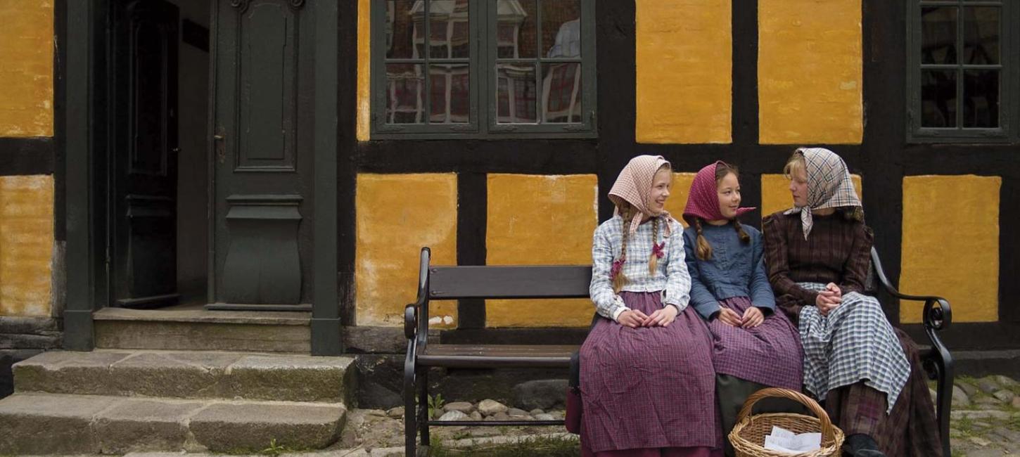 Piger på en bænk i 1864 i Den Gamle By i Aarhus
