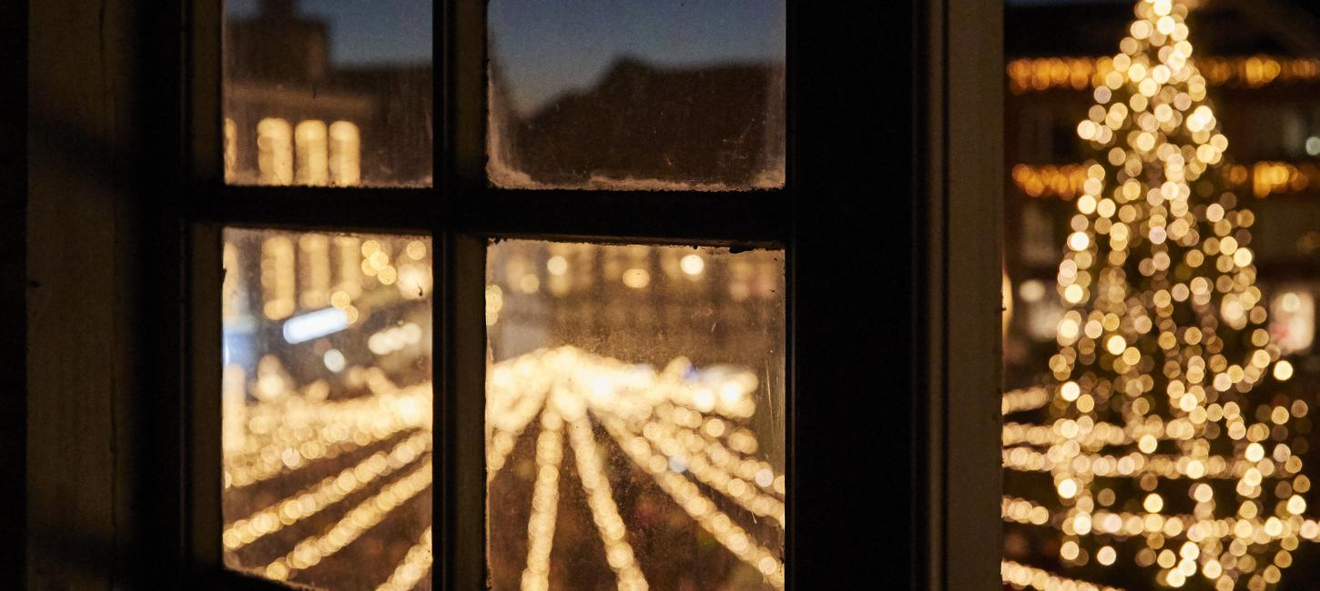 Juletræet ses gennem et vindue i Randers by
