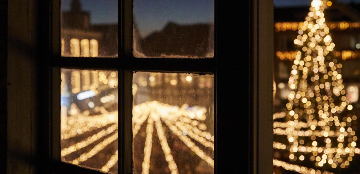 Juletræet ses gennem et vindue i Randers by