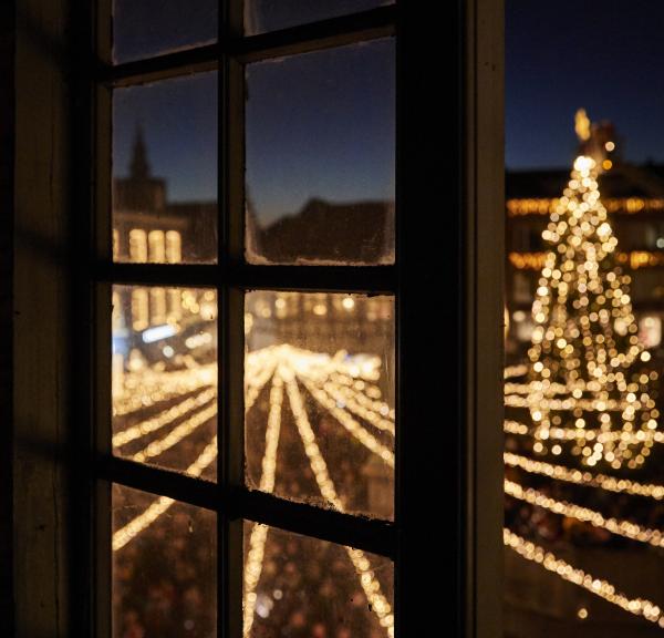Juletræet ses gennem et vindue i Randers by